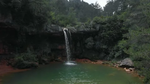 Acercamiento con drone a una cascada ubicada en un idilico entorno natural 動画素材 134642143