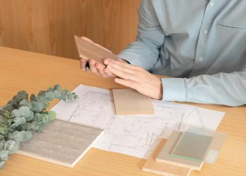 Achitect worinking on interior design picking up different samples of materia Foto stock