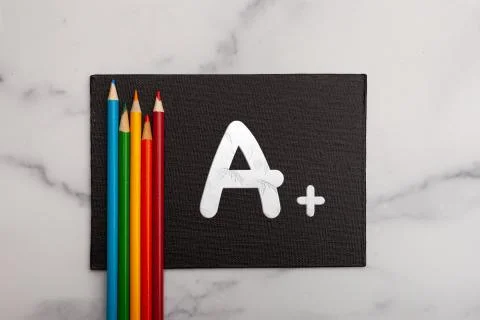 Achivement highest grade A + plus on black board canvas Stock Photos