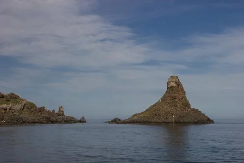 Aci Trezza Sicily rocky islands near the coast, blue sky and beautiful blue sea Stock Photos