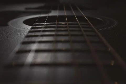 Acoustic guitar close-up. Selective focus. Visible neck, strings, soundboar.. Stock Photos
