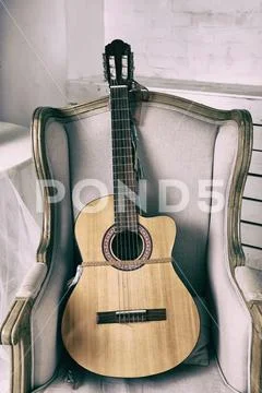 Acoustic Guitar On An Old Armchair