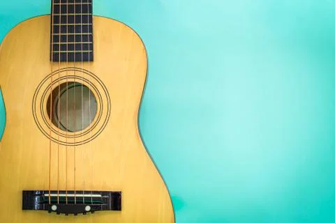 Acoustic guitar resting against a green background Stock Photos