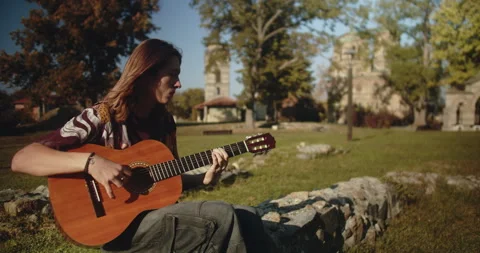 Acoustic guitar young player playing music in medieval ruins Video stock 293745416