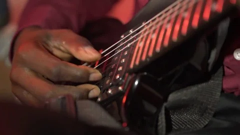Acoustic six-string guitar. The black man plays the guitar. Club lighting. Very Stock Footage 82338547