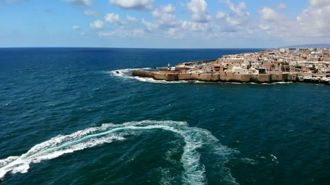 Acre (Akko) Drone fly towards lighthouse with boat in foreground Stock Footage 169056434