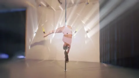 Acro dancer girl doing pole dance tricks on the bar. Slow motion Vídeo Stock 322568296