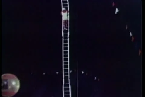 Acrobat climbing high dive ladder at carnival Video stock 11353376