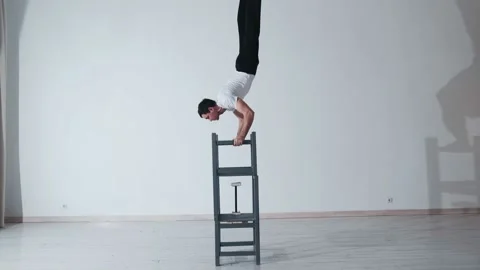 The acrobat keeps balance on the chairs. Acrobatic number without insurance Video stock 151646635