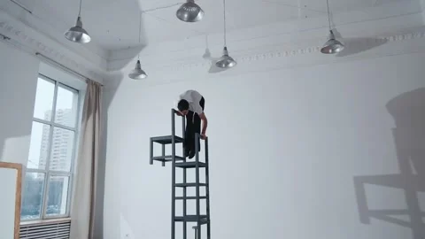 The acrobat keeps balance on the chairs. Acrobatic number without insurance Video stock 151647472