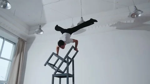 The acrobat keeps balance on the chairs. Acrobatic number without insurance Video stock 151647584
