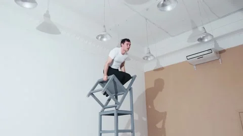 The acrobat keeps balance on the chairs. Acrobatic number without insurance Video stock 151647830