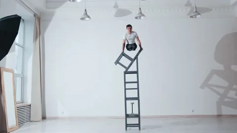 The acrobat keeps balance on the chairs. Acrobatic number without insurance Video stock 151647984