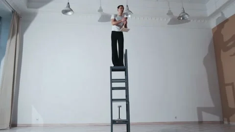 The acrobat keeps balance on the chairs. Acrobatic number without insurance Video stock 151648115