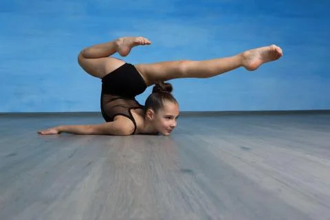 Acrobat standing in back bend pose on blue background. Yoga backbend gymnasti Stock Photos