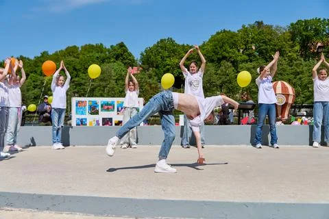 Acrobatic dance performance with cheering volunteers and colorful balloons Fotos de archivo