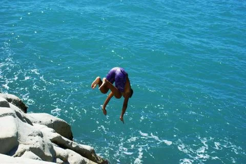 Acrobatic dive from cliff Stock Photos