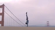 Acrobatic Ethnic Woman Balances On Her Hands By The Golden Gate Bridge Stock Footage