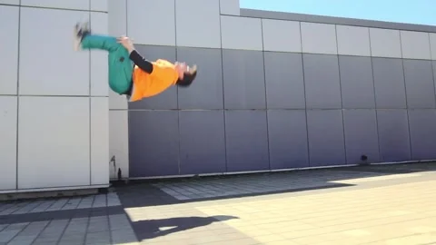 Acrobatic guy jumping back somersault and dancing break dance outdoors Stock Footage 295069143