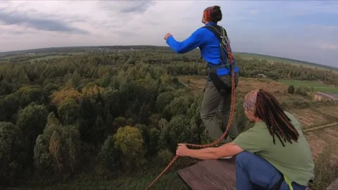 Acrobatic trick with a jump from a 30-meter tower rope jumping Stock Footage 202103440