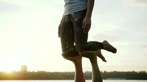 Acrobatic yoga in the park. Young man and woman practicing acrobatic yoga. HD Stock Footage