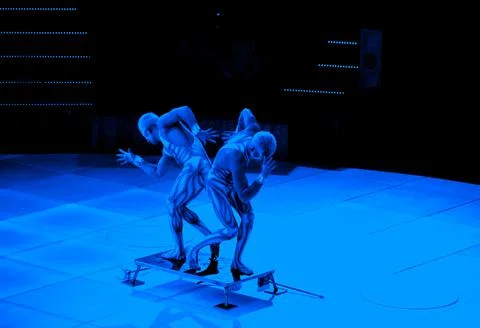 Acrobats in neon light stand in pose Stock Photos