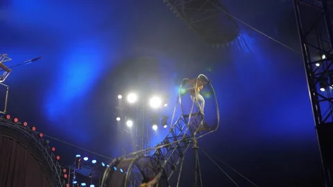 Acrobats on a rotating death wheel performing under the dome of the circus. Stock Footage 310655494