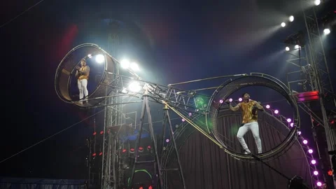Acrobats on a rotating death wheel performing under the dome of the circus. Stock Footage 315859606