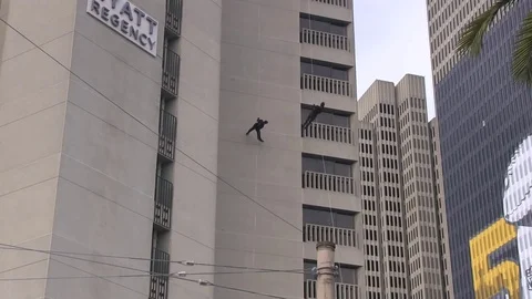Acrobats swing on the side of a building Video stock 77359317