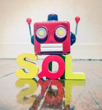 The acronym SQL with a robot head  on a wooden floor with reflection Stock Photos