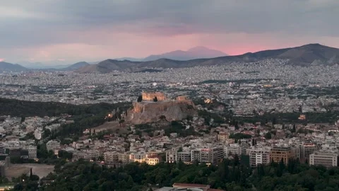 Acropolis and Parthenon illuminated at sunset overlooking Athens cityscape in Stock Footage 345372109