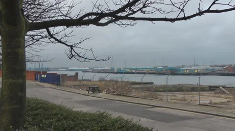 Across old ship yard with dry docks, zoom into modern cargo ship Stock Footage 1090396