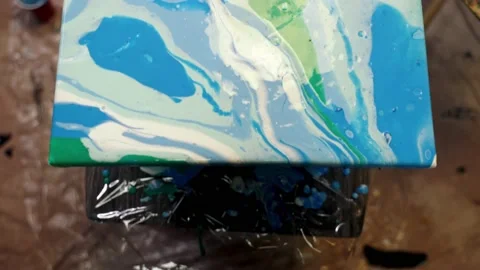 Acrylic paint is spreading over the canvas. Artistic collaboration in workshop. Video stock 156380953