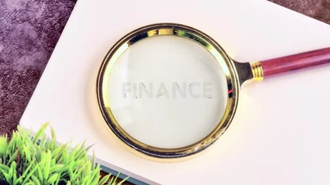 The act of using a magnifying glass to look closely at finance terms. It Stock Footage 341318218
