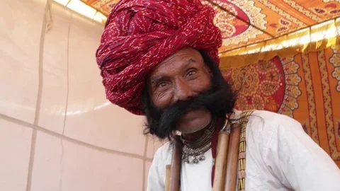 Acting and smiling man with big moustacheand a red turban and tradition dress Stock Footage 69768041