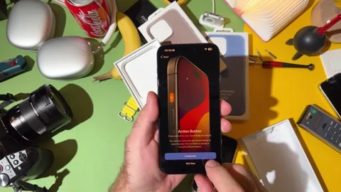 Action button on the new titanium iPhone 15 Pro in a creatively designed room Stock Footage 251889960