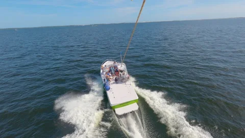 Action cam POV of speedboat pulling person parasailing rising into air in Stock Footage 242392872