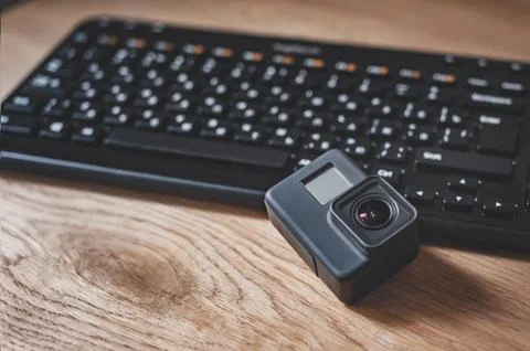 Action-Camera on the background of a black keyboard on a wooden table. 스톡 사진