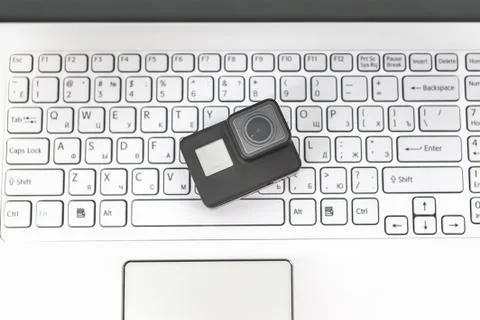Action-camera on the background of a white laptop keyboard. Stock Photos