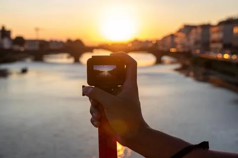 Action camera in the hand of a guy on the background of St Trinity Bridge.  Stock Photos
