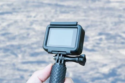 Action camera in hand on skiing concept. Close up. Blank screen for mockup. S Stock Photos