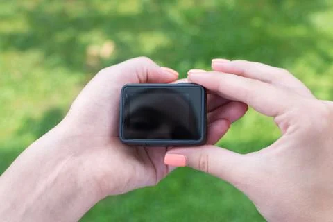 Action camera in hands. Blank screen for mockup. Close-up. Stock Photos