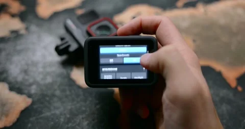 Action camera held in hand, changing menu settings on rear touchscreen Stock Footage 304957021