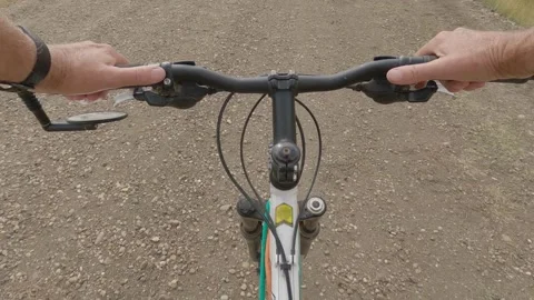 Action camera looking down at a mountain bike riding along a gravel trail. Stock Footage 287107781