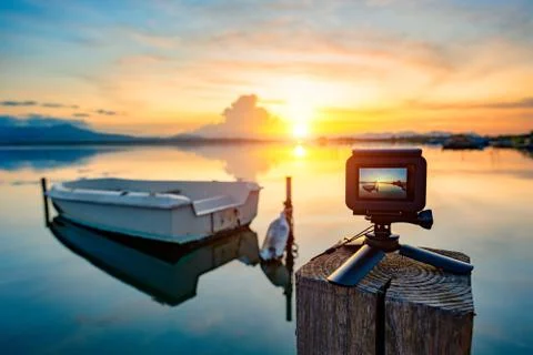 Action camera on mini tripod over a wooden pier, taking video on the pond at  Stock Photos