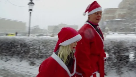 Action camera moves behind crowd of Santa Clauses running walking taking selfie Stock Footage 70633958