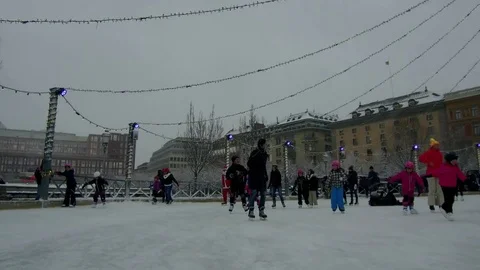 Action camera moves smoothly in between crowd of people ice skating in a rink Stock Footage 70640489