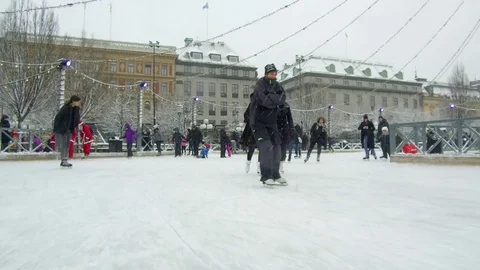 Action camera moves smoothly in between crowd of people ice skating in a rink Stock Footage 70641070