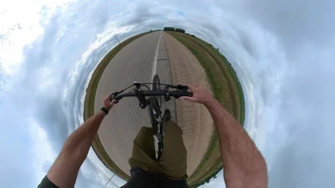 Action camera POV as a 360 degree tiny planet style video of a person on bike Stock Footage 248645510