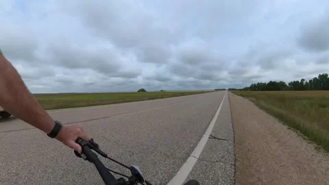 Action camera POV of riding a bicycle along the side of a paved two-lane highway Stock Footage 248645564
